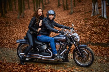 Sonbaharda ormanda helikopterli bir çift motosikletli..