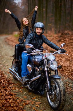 Sonbaharda ormanda helikopterli bir çift motosikletli..
