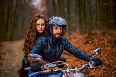 Sonbaharda ormanda helikopterli bir çift motosikletli..