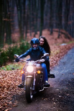 Sonbaharda ormanda helikopterli bir çift motosikletli..