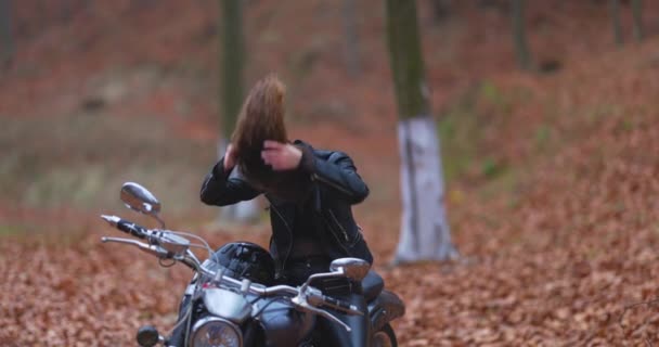Mujer Pelo Largo Motociclista Bosque Otoño Arregla Cabello Cámara Lenta — Vídeos de Stock