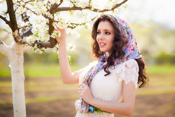 Baharda çiçek açan ağaçların yanında uzun saçlı güzel bir kadının portresi..