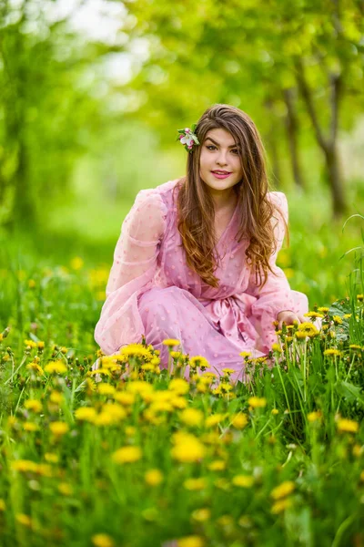 ピンクのドレスを着た若い女性が花のりんごの横に立って春の肖像画を — ストック写真