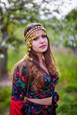 beautiful woman in traditional gypsy dress posing in nature in spring