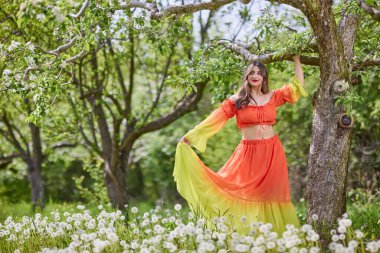 Güzel bir bahar gününde doğada elbise giymiş bir kadının portresi.