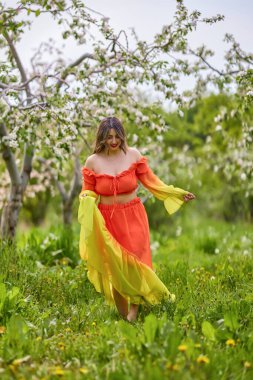 Güzel bir bahar gününde doğada elbise giymiş bir kadının portresi.