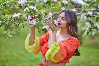 Güzel bir bahar gününde doğada elbise giymiş bir kadının portresi.