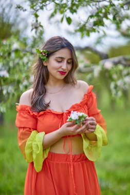Güzel bir bahar gününde doğada elbise giymiş bir kadının portresi.