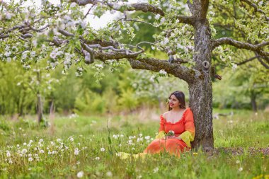 Güzel bir bahar gününde doğada elbise giymiş bir kadının portresi.