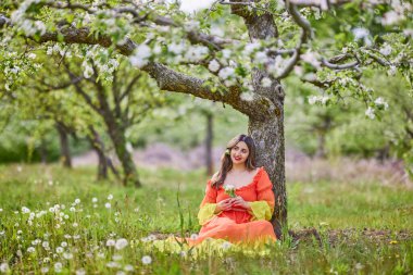 Güzel bir bahar gününde doğada elbise giymiş bir kadının portresi.