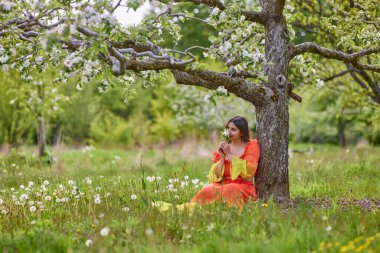 Güzel bir bahar gününde doğada elbise giymiş bir kadının portresi.