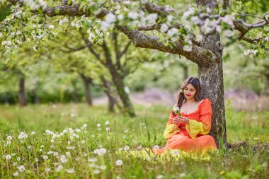 Güzel bir bahar gününde doğada elbise giymiş bir kadının portresi.