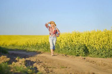 Portrait of a middle-aged woman in the rapeseed chain.