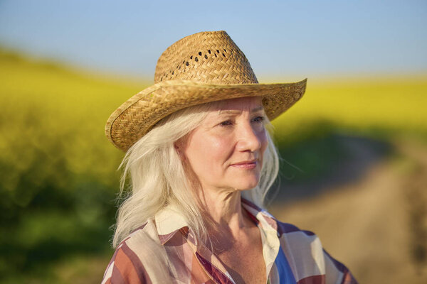 Portrait of a middle-aged woman in the rapeseed chain.
