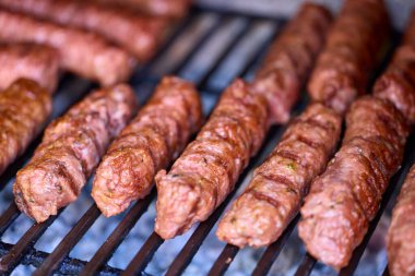 Mangalda mici ya da mititei denilen rulo köfteleri hazırlıyorum. Izgarayı alev ve dumanla yakın..