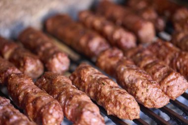 Mangalda mici ya da mititei denilen rulo köfteleri hazırlıyorum. Izgarayı alev ve dumanla yakın..