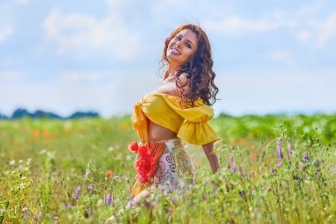 Haşhaş tarlasında çiçekli çekici bir kadın..