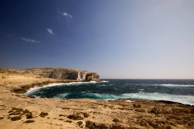Kayalık bir deniz kıyısına sahip güzel bir manzara.