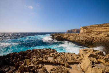Kayalık bir deniz kıyısına sahip güzel bir manzara.