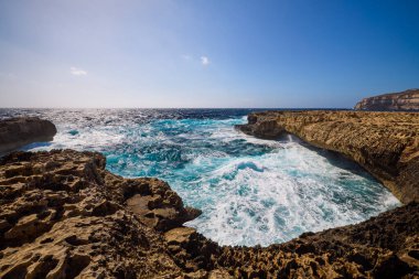 Kayalık bir deniz kıyısına sahip güzel bir manzara.