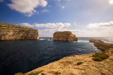 Kayalık bir deniz kıyısına sahip güzel bir manzara.