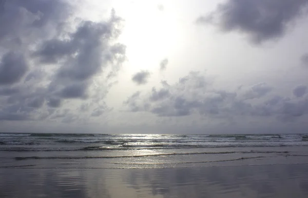 Nubes sobre el océano brillante - vista desde la playa húmeda —  Fotos de Stock