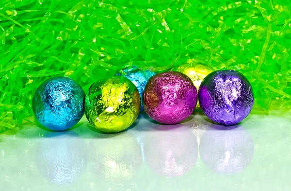 Foil wrapped eggs and grass for Easter — Stock Photo, Image