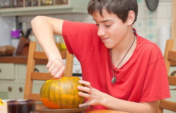 Padre e hijo tallando calabaza de Halloween en una mesa de cocina —  Fotos de Stock