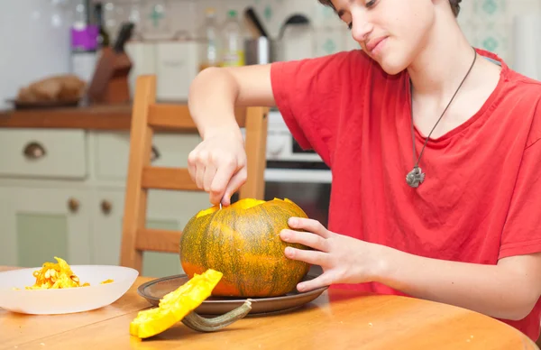 Padre e hijo tallando calabaza de Halloween en una mesa de cocina —  Fotos de Stock