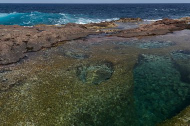 Gran Canaria, kuzey kıyısındaki sarp kayalıkların altındaki sakin kaya havuzları eski lav akıntısı Galdar bölgesi tarafından inşa edilen volkanik platform kayaları ile okyanustan ayrılır.