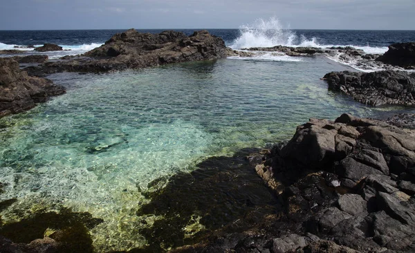 Gran Canaria, calm rock pools under steep cliffs of the north coast are separated from the ocean by volcanic rocks of platform  constructed by old lava flowsPunta de Galdar area