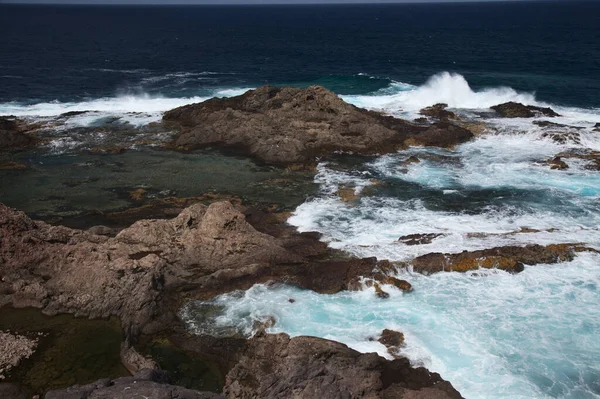 Gran Canaria, calm rock pools under steep cliffs of the north coast are separated from the ocean by volcanic rocks of platform  constructed by old lava flowsPunta de Galdar area