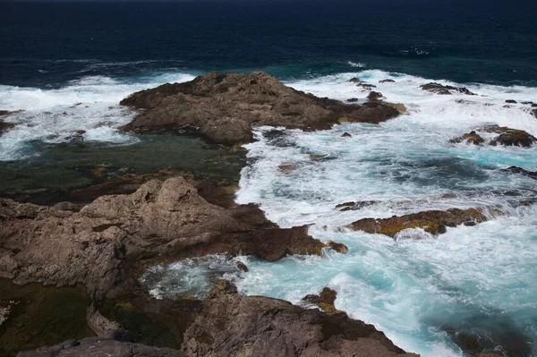 Gran Canaria, calm rock pools under steep cliffs of the north coast are separated from the ocean by volcanic rocks of platform  constructed by old lava flowsPunta de Galdar area