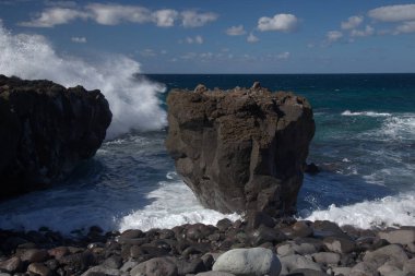 Gran Canaria, kuzey batı kıyısı doğal yüzme havuzları etrafında Salinas de Agaete, eski aşınmış karanlık lav platformuna karşı dalgalar kırılıyor.