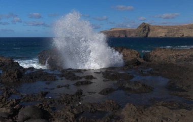 Gran Canaria, kuzey batı kıyısı doğal yüzme havuzları etrafında Salinas de Agaete, eski aşınmış karanlık lav platformuna karşı dalgalar kırılıyor.