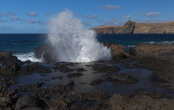 Gran Canaria, kuzey batı kıyısı doğal yüzme havuzları etrafında Salinas de Agaete, eski aşınmış karanlık lav platformuna karşı dalgalar kırılıyor.