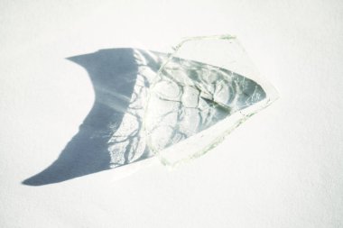 Güneş ışığında kırık bir cam parçası ve gölgede ilginç bir doku var.