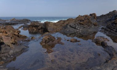 Gran Canaria, north coast, rockpools around Puertillo de Banaderos area protected from the ocean waves by volcanic rock barrier clipart