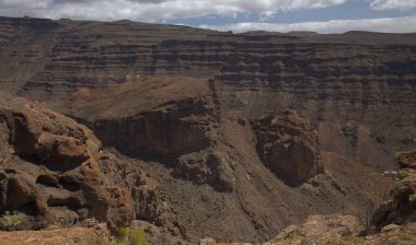 Gran Canaria, adanın güney kısmının Barranco de Arguinegun sarp ve dik kaya duvarlı derin vadi boyunca uzanan manzarası, Fil kayası kemerini ziyaret eden dairesel yürüyüş rotası ve çeşitli manzaralar.
