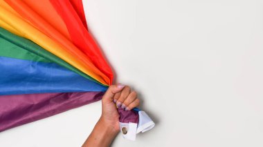 Kopya alanı olan beyaz arkaplanda LGBT gurur bayrağını tutan kadın.