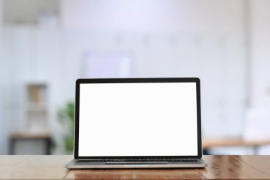 Ofisteki ahşap masada beyaz ekranlı bilgisayar laptopu.. 