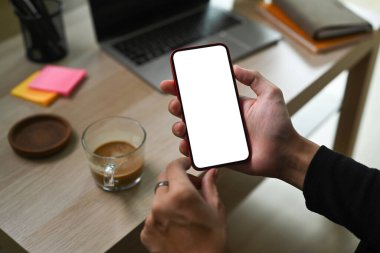 Oturma odasında kanepede otururken elinde akıllı bir telefon tutan adamı kapat..