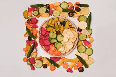 Beyaz arka planda kurutulmuş sebze cipsleri.