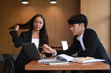 İki başarılı iş adamı ofiste belge ve fikirleri tartışıyor..