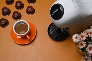 Kahve makinesinin ve kahverengi deri kapsüllerin üstünde..