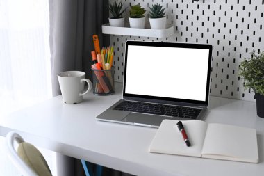 Bilgisayarı, ev bitkilerini ve defterleri ofis masasına kopyala.