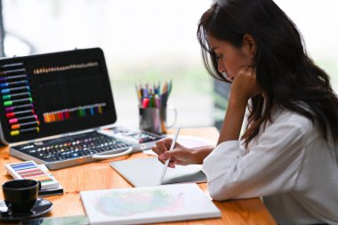 Yan görünüm yaratıcı tasarımcısı Stylus kalem tutuyor ve ofiste dijital tabletle çalışıyor.