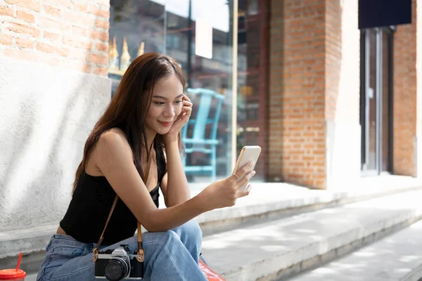 Neşeli Asyalı Kadın Şehirde Dışarıda Otururken Akıllı Bir Telefon Görüşmesi — Stok fotoğraf