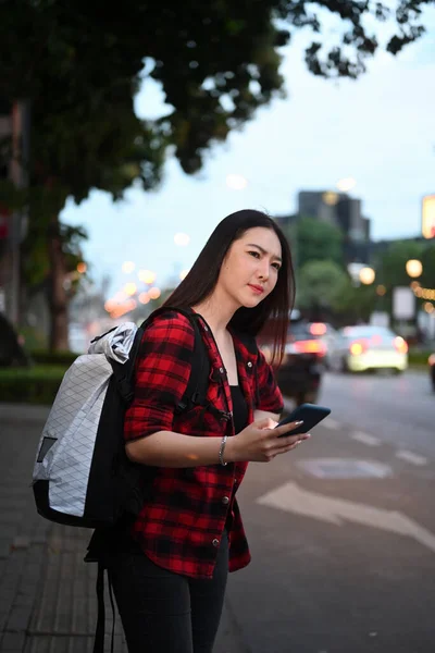 年轻的亚洲女子在城市的公路上等出租车 — 图库照片