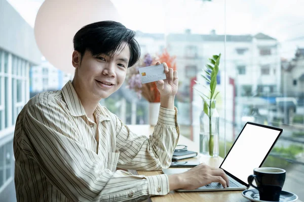 Χαρούμενος Νεαρός Ασιάτης Που Κρατάει Πιστωτική Κάρτα Και Χαμογελάει Στην — Φωτογραφία Αρχείου
